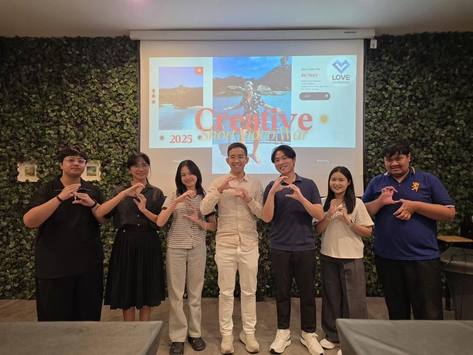 Creative team members posing in front of a presentation screen at a workshop.
